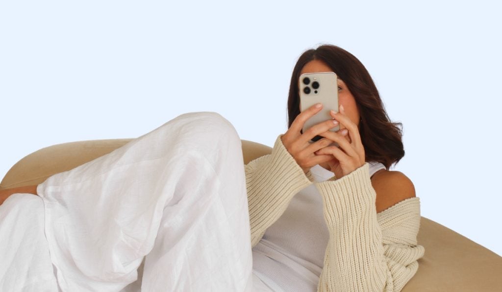 woman hold phone up reading about 10 Brilliant Habits To Organize Your Entire Life