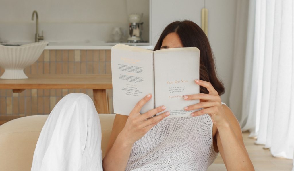 college students holds book while learning about the Millionaire Morning Routine as a Student