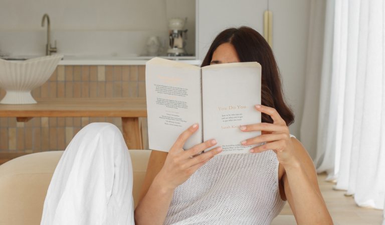 college students holds book while learning about the Millionaire Morning Routine as a Student