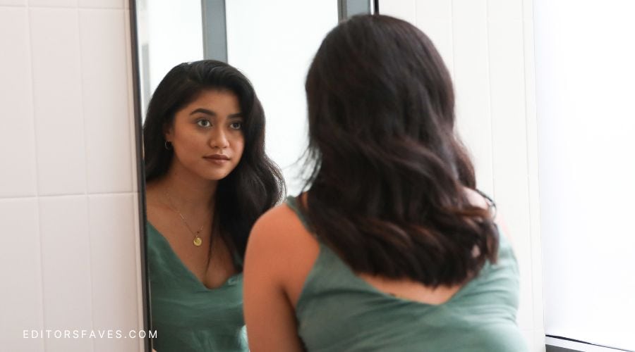 woman looking in mirror, happy now that she knows these 15 Ways to Love Yourself More