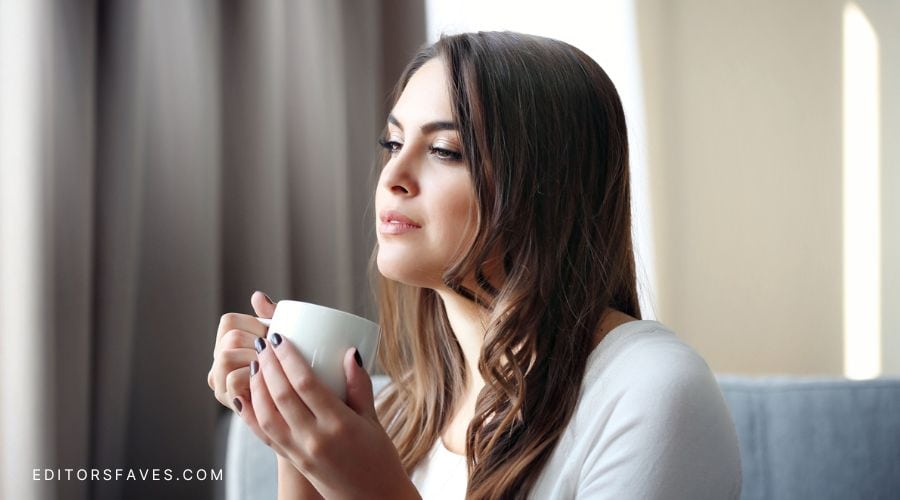 Woman holding coffee cup contemplating some ways to Overcome the Fear of Not Being Good Enough