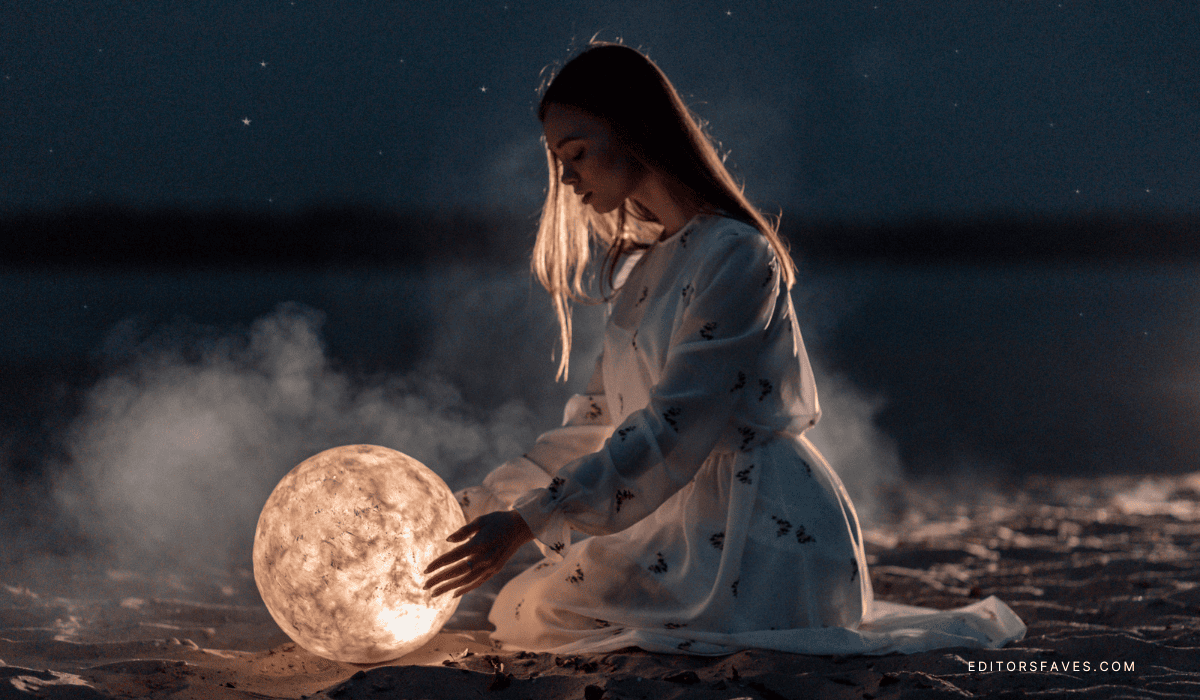 woman holding moon lamp as she learns What is devine feminine energy and how do you embody it